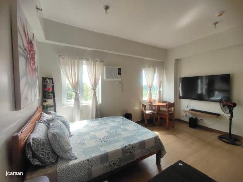 a bedroom with a bed and a flat screen tv at Happy Stays B - End Unit Greenery View at SMDC Hope Residences in Trece Martires