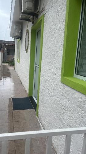 a green door on the side of a building at Chalé Orquidea in São Sebastião