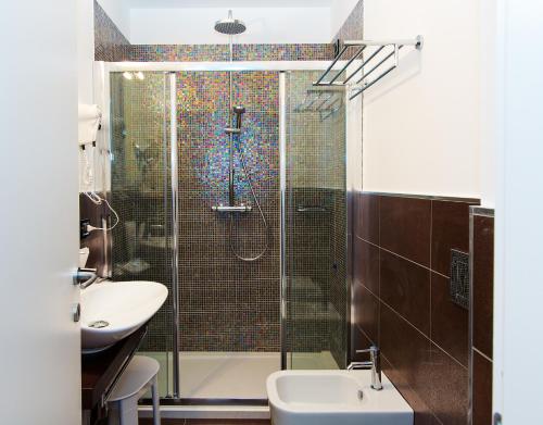 a bathroom with a shower and a toilet and a sink at Hotel Mainè in Finale Ligure