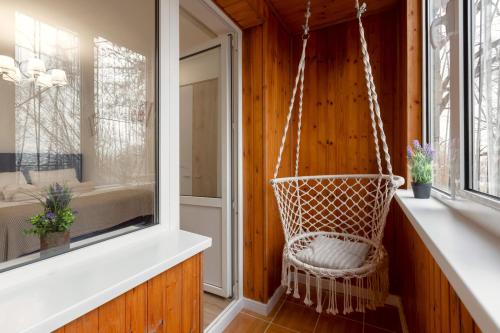 a hanging chair in a room with a window at Modern Traditional apartment in Chişinău
