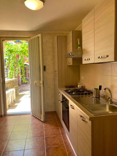 uma cozinha com um lavatório e um fogão forno superior em Serendipity Apartment em Castelmola