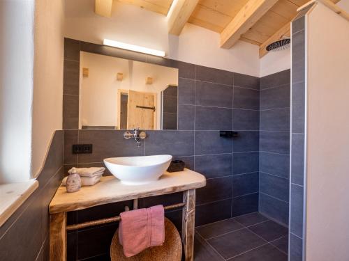 a bathroom with a sink and a mirror at Ferienhaus Weberhof in Hopfgarten im Brixental