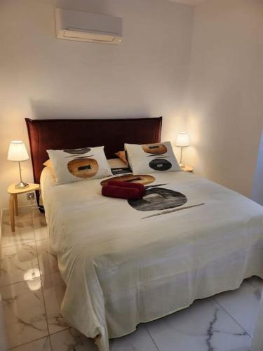 - une chambre avec un grand lit blanc et deux lampes dans l'établissement Appartement dans le 8e arrondissement de Lyon (T2), à Lyon