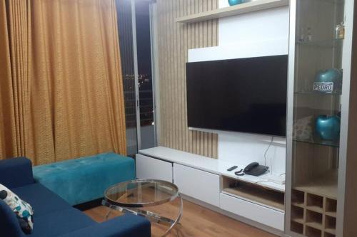 a living room with a blue couch and a flat screen tv at Bonito departamento VIP estreno en Condominio in Lima