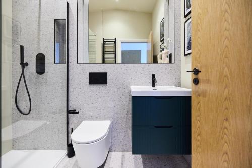 a bathroom with a toilet and a sink and a shower at The South Woodford Place - Adorable 2BDR Flat with Balcony in London
