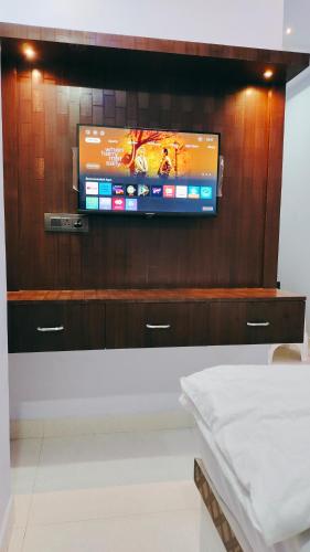 a flat screen tv on top of a wooden wall at Hotel Dwarika in Chandrapur