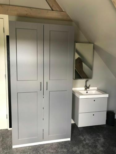 a bathroom with a white cabinet and a sink at welkom bij 5 in Den Ilp