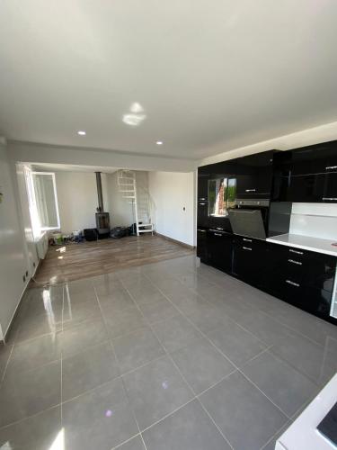 an empty living room with a kitchen and a floor at La louette in Magny-le-Hongre