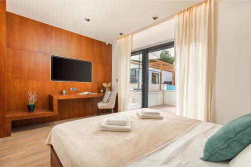 a bedroom with a bed and a desk and a television at Villa Istria Green in Kršan