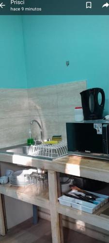 a kitchen counter with a sink and a microwave at El Roble cabañas tepa in Pucón