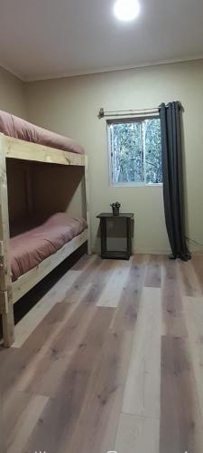 a bedroom with a bunk bed and a window at El Roble cabañas tepa in Pucón