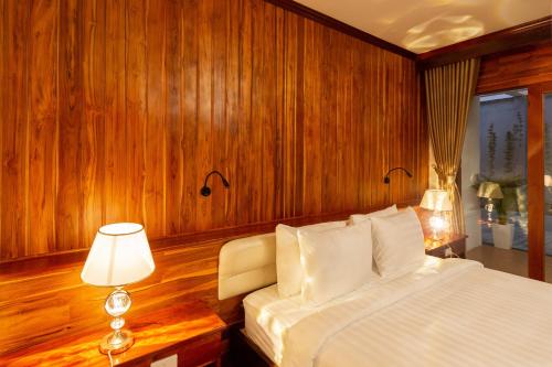 a bedroom with a bed and a table with a lamp at LuangPrabang Center Hotel in Luang Prabang