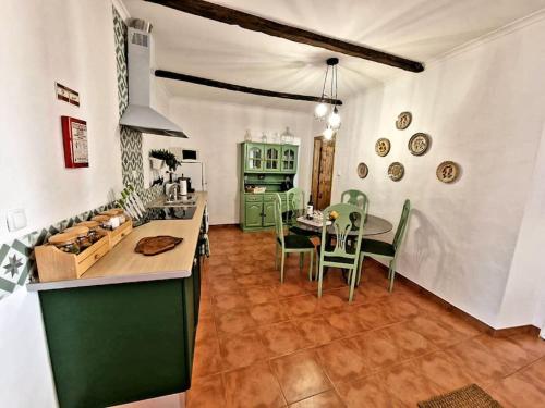 eine Küche und ein Esszimmer mit einem Tisch und Stühlen in der Unterkunft Casa da Enxota in Póvoa de São Miguel