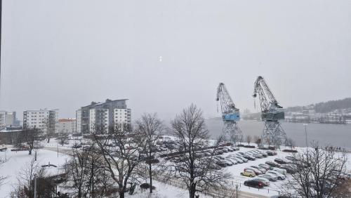 a parking lot with cars and cranes in a city at First Hotel Statt Örnsköldsvik in Örnsköldsvik