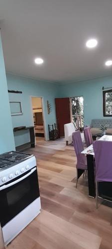 a living room with a stove and purple chairs at El Roble cabañas tepa in Pucón