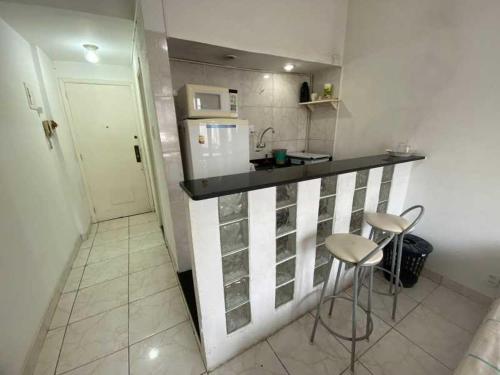 a small kitchen with a counter and two stools at Residencial -Copacabana -Praia in Rio de Janeiro