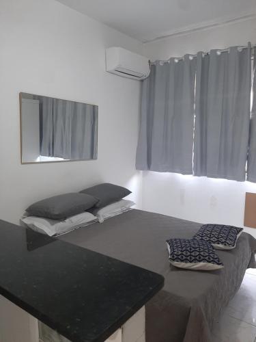 a room with two beds and a table with a mirror at Residencial -Copacabana -Praia in Rio de Janeiro