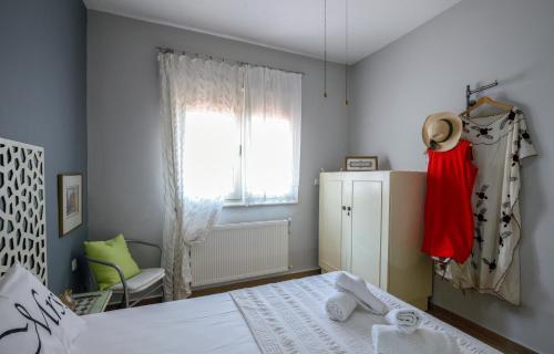 a bedroom with a bed and a window at Sophia houses by the sea in Nea Kalikratia