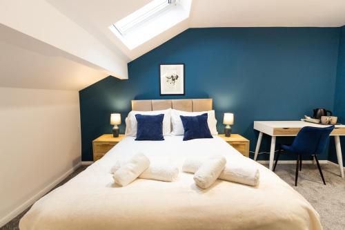 1 dormitorio con 1 cama grande y paredes azules en Suite 7 - Family Room in the Heart of Oldham en Oldham