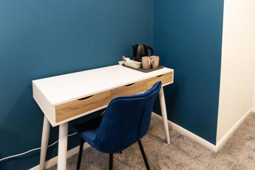 a desk with a blue wall and a blue chair at Suite 7 - Family Room in the Heart of Oldham in Oldham