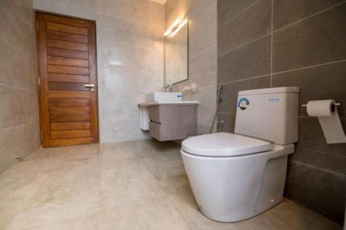 a bathroom with a white toilet and a sink at Kings Hantana in Kandy