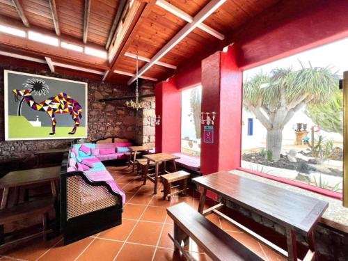 un restaurante con paredes rojas, mesa y bancos en Doble con desayuno incluido, Wifi gratis, estupenda piscina en Yaiza en Yaiza