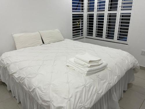 un letto bianco con lenzuola e asciugamani bianchi di The Lonely Mountain a Mataffin
