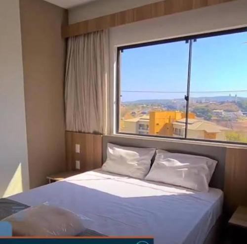 um quarto com uma cama e uma janela grande em Resort Praias do Lago Park em Caldas Novas