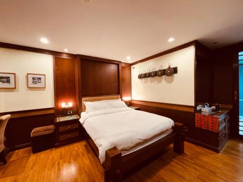 a bedroom with a bed with a wooden headboard at Urban sathorn bangkok in Thung Maha Mek