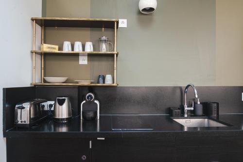 una cucina con bancone nero e lavandino di L'atelier de Luc, Paris 20eme a Parigi