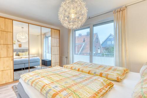 a bedroom with two beds and a chandelier at Haus Flair in Norderney