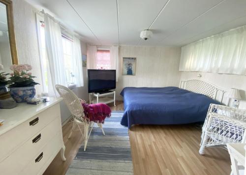 una camera con letto blu e televisore di Cozy cottage in Vejbystrand near the beach a Vejbystrand