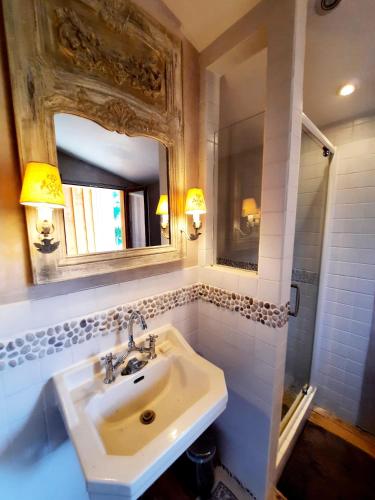 une salle de bain avec un lavabo et un miroir dans l'établissement Pierres et Jardins, à Senlis