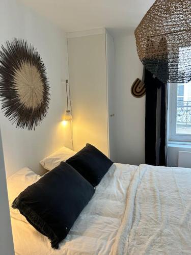 - une chambre dotée d'un lit avec un oreiller noir dans l'établissement Coup de cœur à Trouville, à Trouville-sur-Mer
