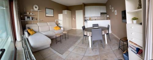 a living room and kitchen with a couch and a table at Superbe studio avec une magnifique vue sur la mer. in De Panne