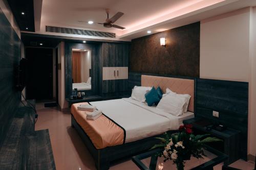 a bedroom with a large bed and a television at Hotel Samudyatha Inn And Suites in Kundapur