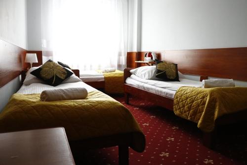 a hotel room with two beds and a window at Sala Bankietowa i Pokoje Gościnne in Sokółka