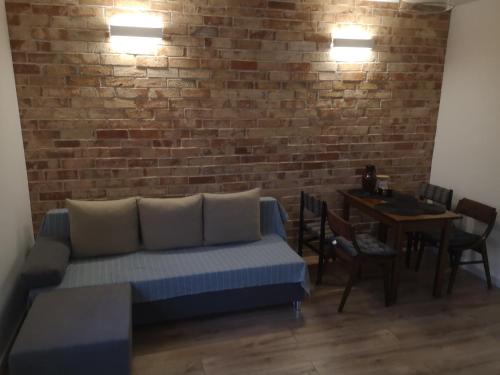 a living room with a couch and a brick wall at apartament Stary Piec Jedlina Zdrój in Jedlina-Zdrój