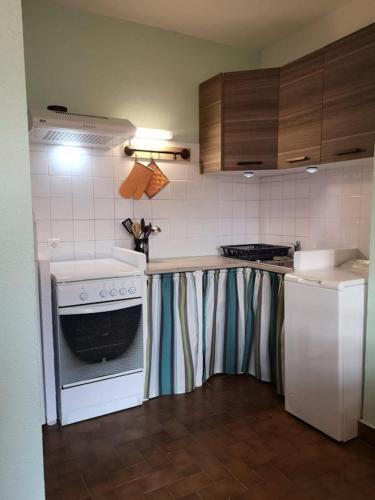 Il comprend une cuisine équipée d'un comptoir avec une cuisinière et un réfrigérateur. dans l'établissement gîte Les Lavandes de Capluc, au Rozier