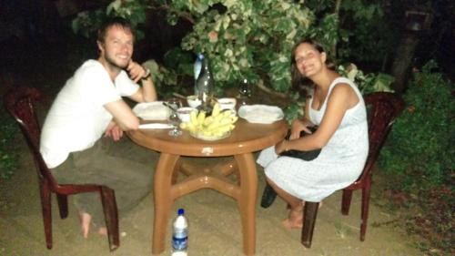 Green Grass Homestay في سيجيريا: رجل وامرأة يجلسون على طاولة