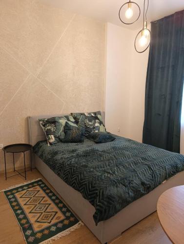 a bedroom with a bed with a green comforter at MH Apartments in Rzeszów