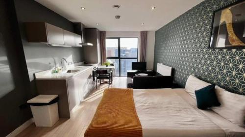 a hotel room with a bed and a kitchen at Modern Studio Apartment by BOLD Apartments in Liverpool