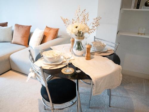 a table with two chairs and a vase with flowers at The Grand Serenity Suite in London