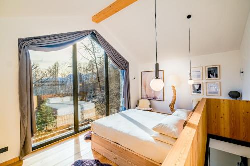 een slaapkamer met een bed en een groot raam bij Hunum in Voga