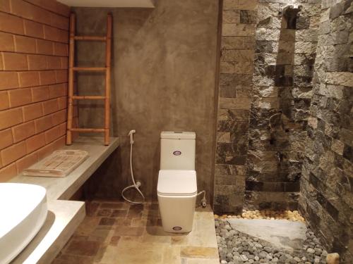 a bathroom with a toilet and a sink at The Brick Wonder in Habaraduwa Central