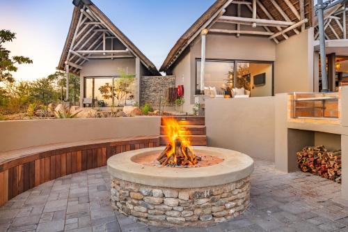 a fire pit in front of a house at Marula Sunrise Lodge, Mjejane Private Game Reserve in Hectorspruit