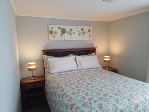 a bedroom with a bed and two lamps on tables at CASA PALI 2 in Puerto Montt