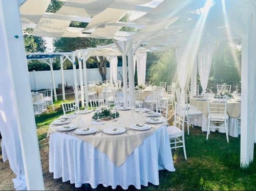 a table set up for a wedding under a white tent at VILLA di L ABBIU FARMHOUSE , ROOMS DESIGN & RELAX in Sorso
