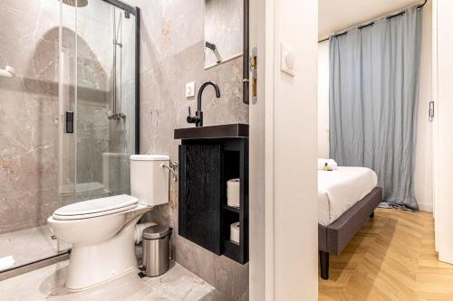 une salle de bain avec toilettes et douche dans l'établissement Appartement moderne pour 4 proche Arc de Triomphe, à Paris