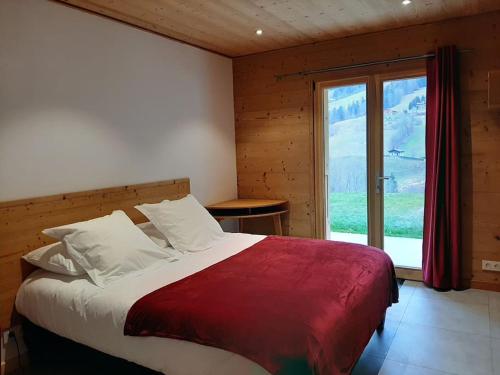 une chambre avec un grand lit avec une grande fenêtre dans l'établissement Chalet Génie des Alpages, 8 personnes, proche stations, à Entremont